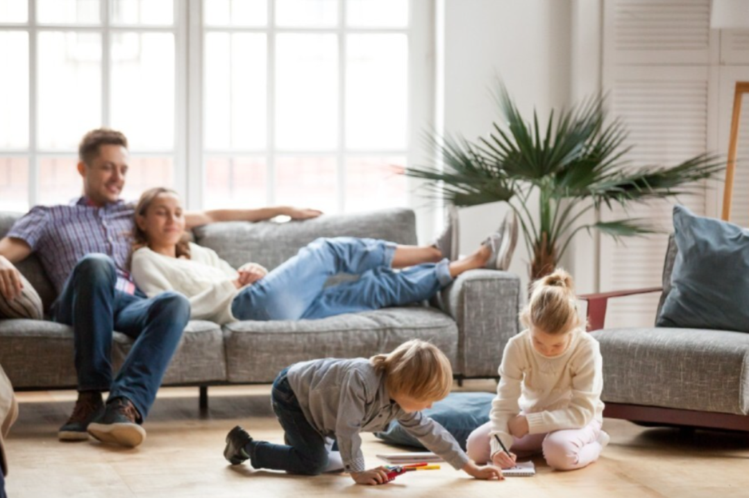 Two parents on the couch watching their children play